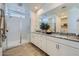 Modern bathroom features a glass-enclosed shower, double vanity, and attractive tile flooring at 8048 E Paloma Ave, Mesa, AZ 85212