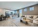 Open-concept living area with a sofa, wood look flooring, and a kitchen island with barstools near a dining area at 8048 E Paloma Ave, Mesa, AZ 85212