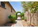 A stone walkway leads to a backyard with an arched trellis and mature landscaping at 8113 S 42Nd Dr, Laveen, AZ 85339