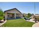 A covered patio overlooks a synthetic lawn and outdoor seating area with mature landscaping at 8113 S 42Nd Dr, Laveen, AZ 85339