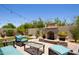Outdoor fireplace and seating area surrounded by a lush landscaped garden at 8113 S 42Nd Dr, Laveen, AZ 85339
