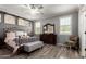 Cozy bedroom with a decorative bed frame, wood floors, and shutters on the windows at 8113 S 42Nd Dr, Laveen, AZ 85339