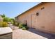 Exterior view of the side of the home with a privacy gate, landscaping, and brick pavers at 8113 S 42Nd Dr, Laveen, AZ 85339