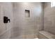 Modern shower featuring gray tile, a built-in niche, and a convenient bench at 8318 W Palo Verde Dr, Glendale, AZ 85305