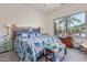 Bright main bedroom with a large window, ceiling fan, and a comfortable bed with blue accents at 839 E Leo Pl, Chandler, AZ 85249