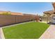 This backyard features artificial turf, gravel, and a paved patio area with a seating arrangement at 9125 E Gelding Dr, Scottsdale, AZ 85260