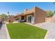 This backyard features artificial turf, gravel, a paved patio, an outdoor grill, and a seating area at 9125 E Gelding Dr, Scottsdale, AZ 85260