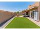 This backyard features artificial turf, gravel, a paved patio area, an outdoor refrigerator, and a seating arrangement at 9125 E Gelding Dr, Scottsdale, AZ 85260