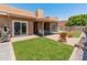 This backyard features artificial turf, pavers, an outdoor grill, an outdoor refrigerator, and a seating arrangement at 9125 E Gelding Dr, Scottsdale, AZ 85260