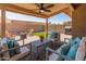 This outdoor living space features a covered patio with a ceiling fan, comfortable seating, and a fire pit area at 9125 E Gelding Dr, Scottsdale, AZ 85260