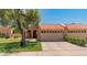 Charming home exterior with a red tile roof, well-maintained lawn, and a mature shade tree at 9125 E Gelding Dr, Scottsdale, AZ 85260