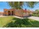 Charming front exterior showcases a well-manicured lawn and mature trees for a picturesque curb appeal at 9125 E Gelding Dr, Scottsdale, AZ 85260