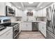 Bright, white kitchen featuring stainless steel appliances, quartz countertops, and modern fixtures at 9125 E Gelding Dr, Scottsdale, AZ 85260