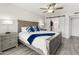 Relaxing main bedroom features cool color tones, a ceiling fan, and a barn door leading to the en suite bathroom at 9125 E Gelding Dr, Scottsdale, AZ 85260