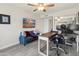 Well-lit home office offers modern comforts with a comfortable blue couch and updated ceiling fan at 9125 E Gelding Dr, Scottsdale, AZ 85260