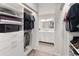 Organized walk-in closet with ample storage, shelving, and access to the well-lit en suite bathroom at 9125 E Gelding Dr, Scottsdale, AZ 85260