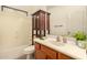 Bathroom vanity with wood cabinetry, sink, toilet, tub, and wood storage cabinet at 9207 W Kirby Ave, Tolleson, AZ 85353