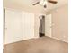 Bedroom features a carpeted floor, ceiling fan, and double closet with sliding doors at 9207 W Kirby Ave, Tolleson, AZ 85353