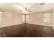 Expansive bedroom features dark hardwood floors, ceiling fan, and large windows at 9207 W Kirby Ave, Tolleson, AZ 85353
