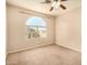 Bedroom features a carpeted floor, ceiling fan, and window overlooking the front yard at 9207 W Kirby Ave, Tolleson, AZ 85353