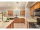 Kitchen with wood cabinets, black appliances, island, tile floors, and sink window at 9207 W Kirby Ave, Tolleson, AZ 85353