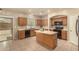 Bright kitchen with wood cabinets, black appliances, central island, and sliding door at 9207 W Kirby Ave, Tolleson, AZ 85353