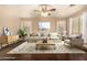 Staged living room with hardwood floors, ceiling fan, sofa, rug, side table, and decorations at 9207 W Kirby Ave, Tolleson, AZ 85353
