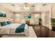 Staged main bedroom features hardwood floors, teal accents, and a bright, inviting atmosphere at 9207 W Kirby Ave, Tolleson, AZ 85353