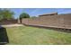 Green backyard with stone retaining wall, gravel bed and block fence at 9330 E Plana Ave, Mesa, AZ 85212