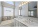 Bathroom with double sinks, bathtub, and arched window at 9330 E Plana Ave, Mesa, AZ 85212