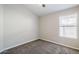 Neutral bedroom features plush carpet, a ceiling fan, and a window with blinds at 9330 E Plana Ave, Mesa, AZ 85212