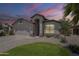 Front exterior view of the home at dusk with a well-manicured lawn at 9330 E Plana Ave, Mesa, AZ 85212