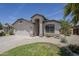 Charming single-story home with desert landscaping, lawn, and attached two-car garage on a sunny day at 9330 E Plana Ave, Mesa, AZ 85212