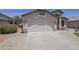 A two car garage with a concrete driveway and desert landscaping at 9330 E Plana Ave, Mesa, AZ 85212