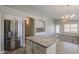 Open kitchen showcasing a granite island, stainless steel appliances and view into adjacent living space at 9330 E Plana Ave, Mesa, AZ 85212