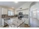 Updated kitchen features granite countertops, stainless steel appliances, mosaic backsplash, and island sink at 9330 E Plana Ave, Mesa, AZ 85212