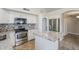 Bright kitchen with granite countertops, white cabinets, mosaic tile backsplash, and stainless steel appliances at 9330 E Plana Ave, Mesa, AZ 85212