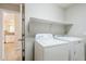 Bright laundry room with white washer and dryer and shelf above at 9330 E Plana Ave, Mesa, AZ 85212