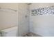 Shower with gray tile and decorative tile inset at 9330 E Plana Ave, Mesa, AZ 85212