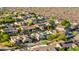Aerial view of desert community with pools, lush trees, and well-maintained homes near desert landscape at 9532 E Knoll Cir, Mesa, AZ 85207