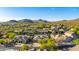 Scenic aerial view of desert community homes with mountain views, lush trees, and clear blue skies at 9532 E Knoll Cir, Mesa, AZ 85207