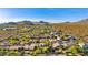 Expansive aerial view of community homes nestled within a desert landscape and beautiful mountain views at 9532 E Knoll Cir, Mesa, AZ 85207