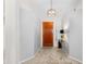 Bright foyer with tile flooring, wood door, and decorative lighting fixture at 9532 E Knoll Cir, Mesa, AZ 85207