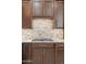 Elegant kitchen featuring granite counters, a tile backsplash, and custom wood cabinets at 9532 E Knoll Cir, Mesa, AZ 85207