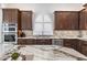 Stylish kitchen featuring stainless steel appliances, granite counters, and custom cabinetry at 9532 E Knoll Cir, Mesa, AZ 85207