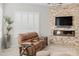 Cozy living room with a stone accent wall, fireplace, and comfortable leather seating at 9532 E Knoll Cir, Mesa, AZ 85207