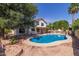 A spacious backyard features a refreshing pool, lush greenery, and a cozy patio area at 987 E Divot Dr, Tempe, AZ 85283