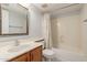 This bathroom features tile floors, an oak vanity, a mirror, and a shower-tub combo with a patterned curtain at 987 E Divot Dr, Tempe, AZ 85283