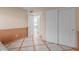 This bedroom features wood-paneled walls, a closet, and tile floors with wooden accents at 987 E Divot Dr, Tempe, AZ 85283