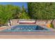 This backyard spa features blue mosaic tiles, a stone surround, and a mural on the privacy wall at 987 E Divot Dr, Tempe, AZ 85283